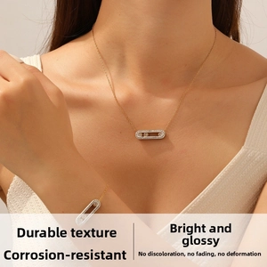 Detail of gold-plated paperclip necklace with sparkling sliding diamond in oval pendant