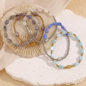 Detail of 18K gold plated beaded bracelets with colorful glass beads on a white stone base