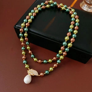 Dettaglio della collana di perle con ciondolo a foglia in zircone e goccia bianca