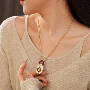 Detail of vintage diamond-set rhombus pendant with amber gemstone on twisted gold chain
