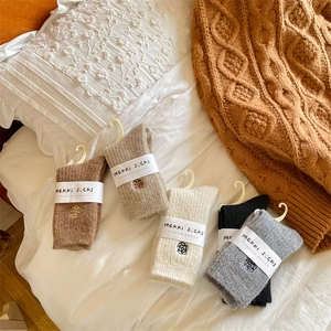 Detail of five pairs of thick winter wool socks with floral embroidery and paper labels