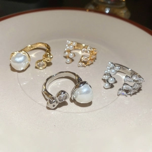 Detail of vintage French style rings with multi-layer pearls and zircons in a ceramic dish