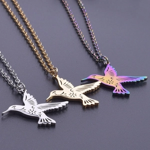 Three hummingbird pendants in gold, silver, and purple stainless steel with laser cut details