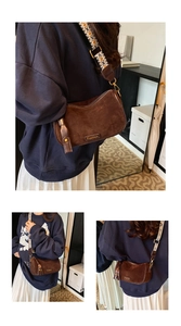 Detail of dark brown suede crossbody bag with decorative wide geometric strap
