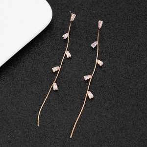 Macro shot of long gold tassel earrings with clear rectangular zircon stones
