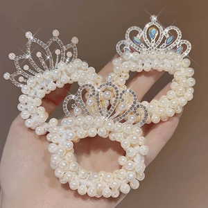 Dettaglio di tre elastici per capelli in perle con corone di strass scintillanti e finitura