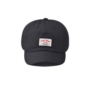 Vintage black short brim baseball cap with a white embroidered logo patch and cotton texture