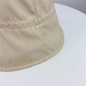 Close-up of beige bucket hat showing high-quality stitching and smooth polyester fabric