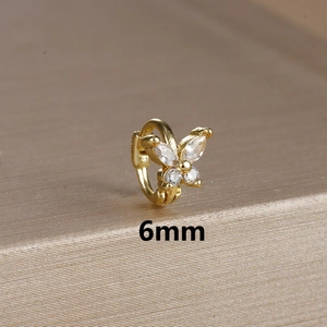 Macro view of 6mm golden butterfly earring with clear zircons on gold textured stand