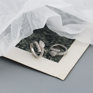 Macro shot of silver zircon hoop earrings on a vintage paper background