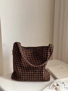 Close-up of vintage brown plaid tweed shoulder bag with soft textured fabric detail