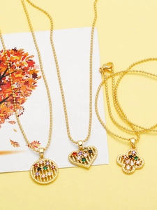 Detail of three gold pendant necklaces with colorful zircon stones in heart and petal shapes