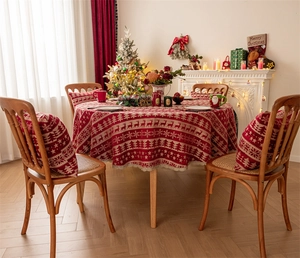 Detailed pattern of red Christmas tablecloth featuring reindeer and gold lace trim