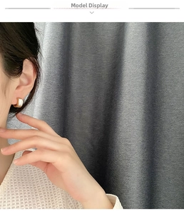 Detail of luxury C-shaped gold-plated hoop earrings with elegant white pearl shell inlay