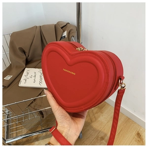 Dettaglio borsa a tracolla cuore rosso in pelle PU con doppia cerniera e finiture dorate