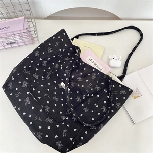 Large black corduroy tote bag with white bow pattern and matching zipper pouch