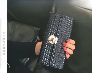 Gros plan d'une pochette matelassée noire avec finition brillante et fermoir rotatif doré