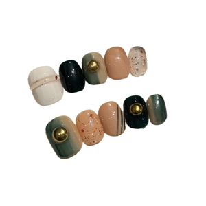 Elegant short press-on nails in dark green and cream white with gold accents
