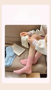 Detail of crew socks featuring star patterns and ribbed knit texture in pastel colors