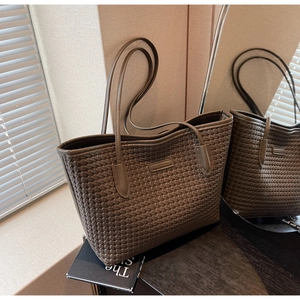 Detail of dark brown woven tote bag showing large capacity and premium faux leather texture
