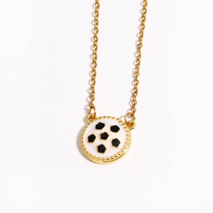 Macro detail of golden football pendant with black and white enamel soccer pattern