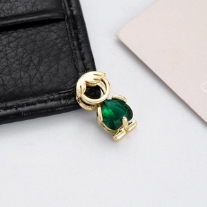 Macro shot of a gold heart pendant with a green zircon stone for DIY jewelry making