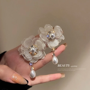 Detail of floral earrings with mesh petals, central pearls, and teardrop pearl drops