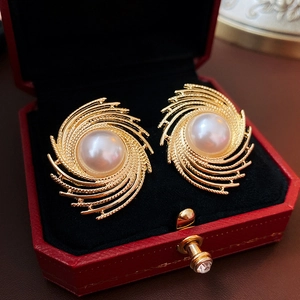 Close-up of vintage irregular spiral pearl earrings in a red luxury jewelry box