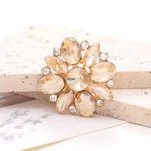 Macro shot of marquise crystal flower accessory with champagne gems on golden base