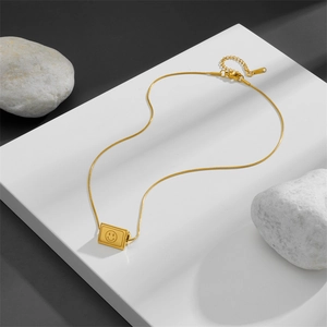 Minimalist gold triangular prism smile necklace with sleek snake chain on white platform