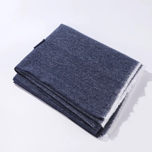 Close-up of dark blue cashmere-feel shawl with white fringe detail and fabric texture