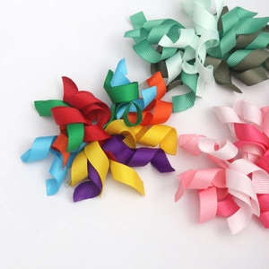 Detailed close-up of handmade rainbow and mixed-color grosgrain ribbon hair bow clips