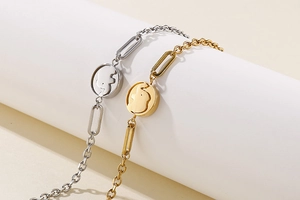 Detail of elegant gold and silver bracelets featuring a round elephant charm pendant