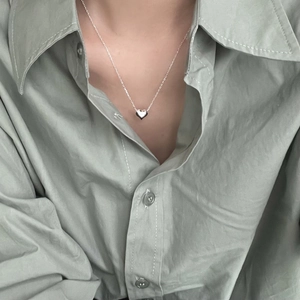 Close-up of minimalist 925 sterling silver heart necklace worn on a female model