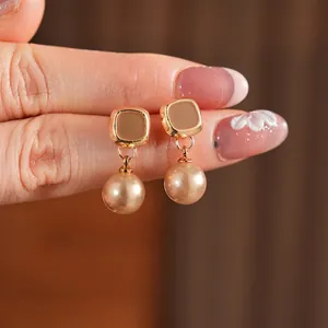 Orecchini pendenti vintage con perle champagne e cornice dorata geometrica lusso