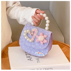 Detail of purple children's bag with pearl handle and rhinestone heart ornament