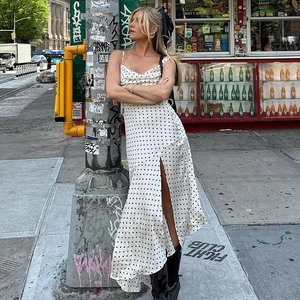 Polka dot camisole dress with cowl neck and side slit shown in a street fashion style