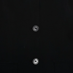Close-up of dual metal buttons and textured woven fabric on this black tube dress