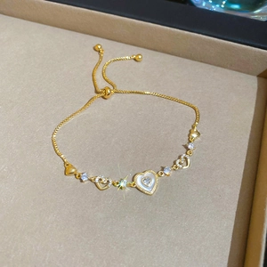 Detail of adjustable gold heart bracelet with white mother of pearl and cubic zirconia