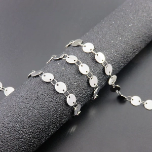 Polished silver stainless steel round disc chain necklace with mirror finish on black stand