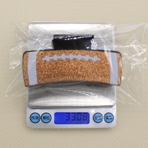 Macro shot of glittery football hair claw on a digital scale showing weight of 33.08g