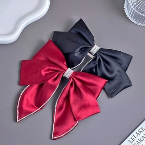 Detail of red and black velvet bow hair clips with rhinestone edges and long tassels
