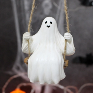 Close-up of a white resin ghost sitting on a wooden swing with natural hemp rope hanging