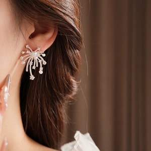 Close-up of starburst pearl earrings with 18K gold plating and sparkling crystals