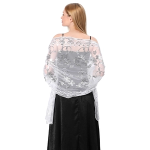 Detail view of a white mesh shawl with silver sequin floral embroidery on a model's back
