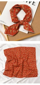 Detail of orange floral cotton linen neck scarf with intricate flower patterns and texture