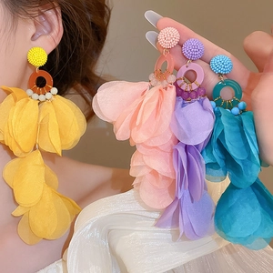 Detailed view of bohemian fabric flower tassel earrings in yellow, pink, and blue shades