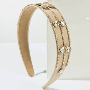 Detail of luxury beige fabric headband with parallel rhinestone chains and crystals