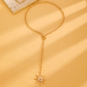 Macro shot of gold sun pendant necklace with minimalist OT toggle clasp design