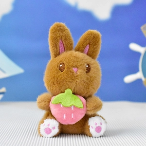 Cute brown plush bunny keychain holding a pink strawberry accessory detail view